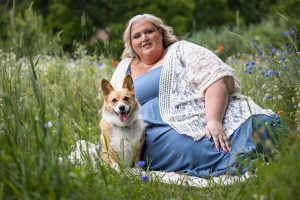 The dog mom is posing at All Who Wander Flower Farm with her corgi in Dundas, ON.